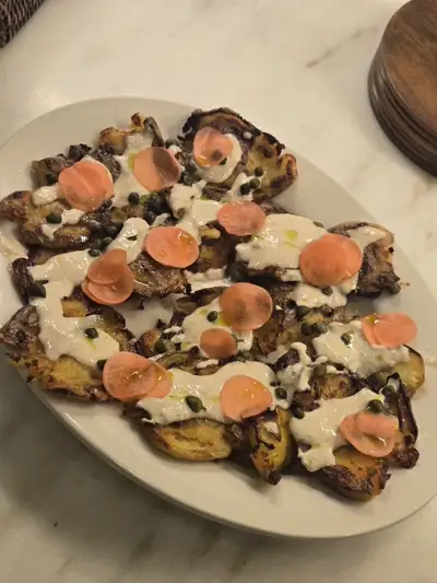 Crispy smashed potatoes with pickled carrots and tahini drizzle — creative comfort food by Chef Mollie
